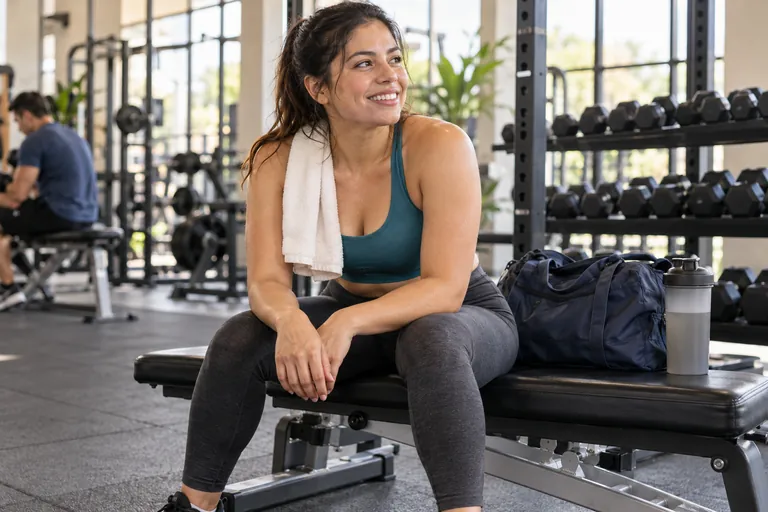 Mujer descansando tras una sesión de fuerza en un gimnasio